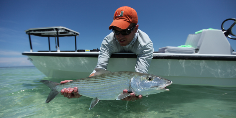 an angler holds a big Islamorada bonefish he caught on fly in Florida bay